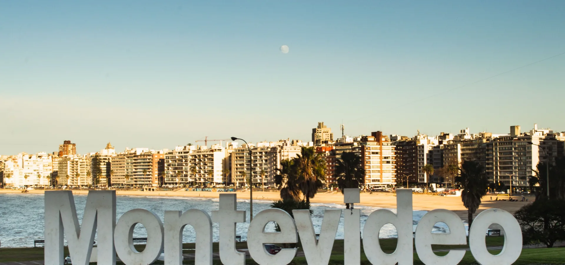 Montevideo landmark sign with city skyline and bea — Seguro de viaje para Uruguay