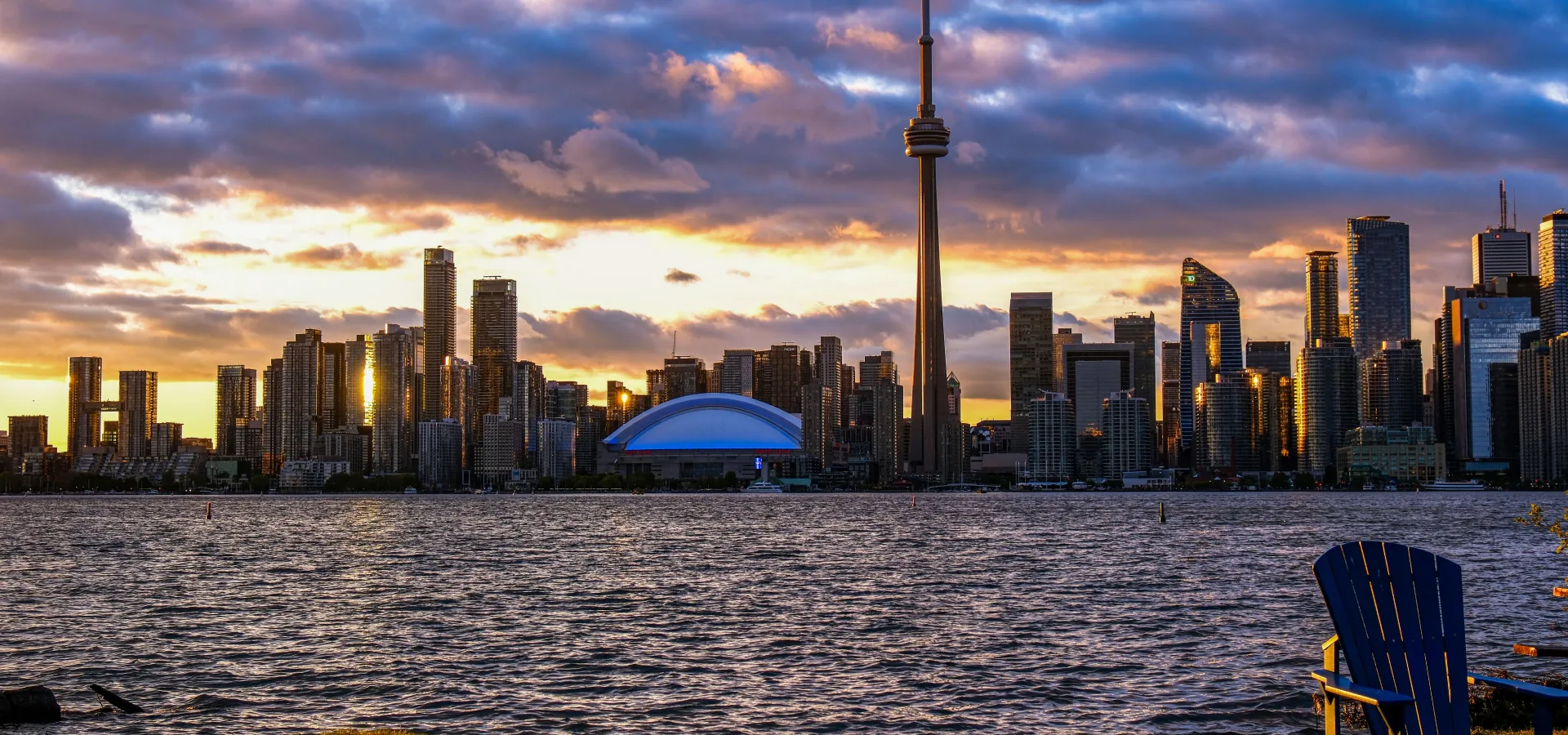 Dramatic sunset view of toronto skyline featuring — Seguro de viaje para Canadá