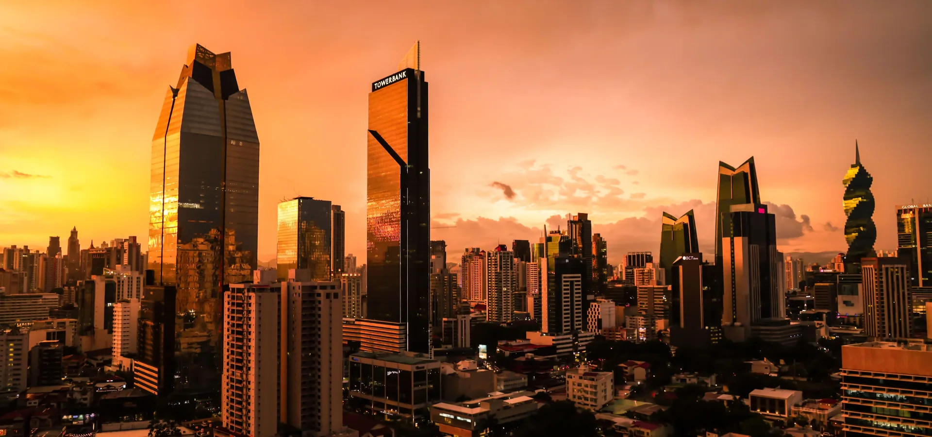 The sun sets over panama citys skyline casting a — Seguro de viaje para Panamá